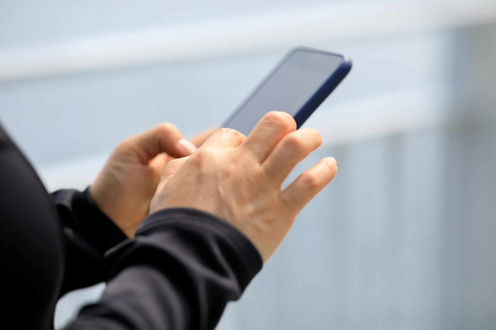 Person using a smartphone outdoors, highlighting the need for mobile-friendly websites to enhance user engagement and search rankings