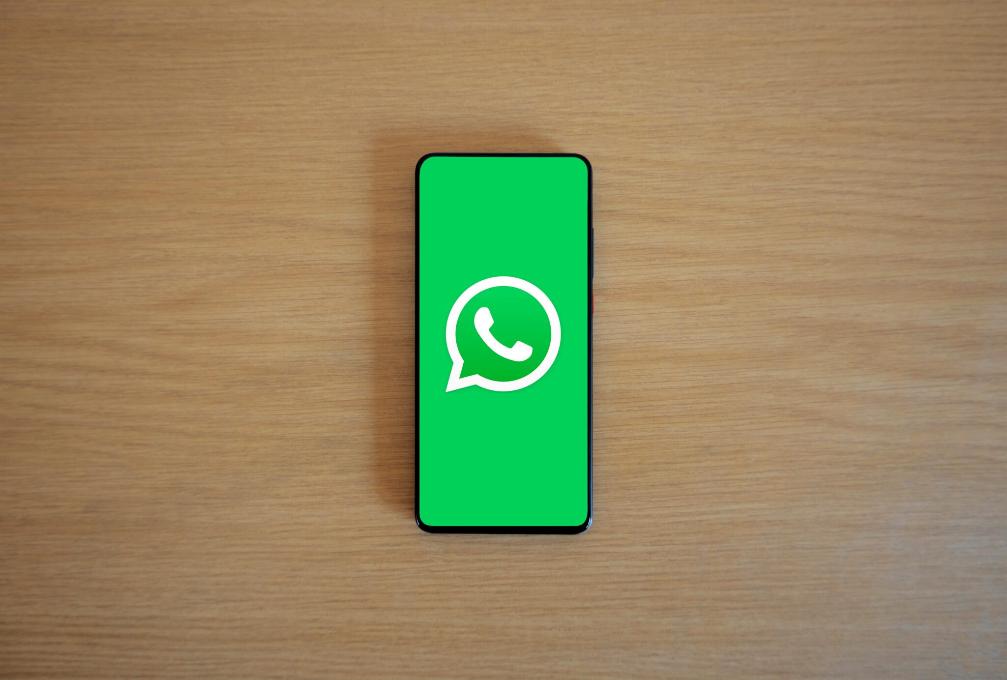 WhatsApp logo on a smartphone screen, symbolizing Jan Koum's success story from food stamps to WhatsApp billionaire