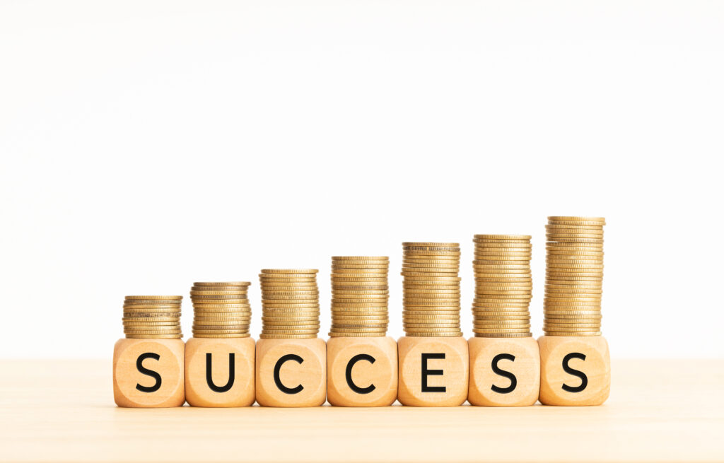 Stack of gold coins spelling out 'SUCCESS' representing entrepreneurs who started from zero