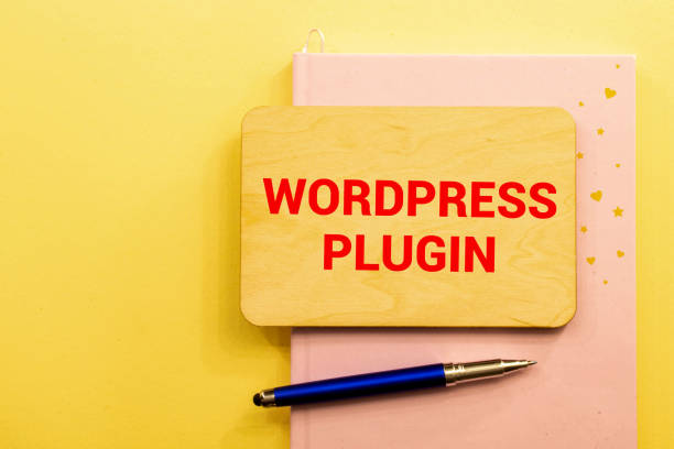 Sign with 'WordPress Plugin' on a desk with a pen, representing tools and resources for small business websites