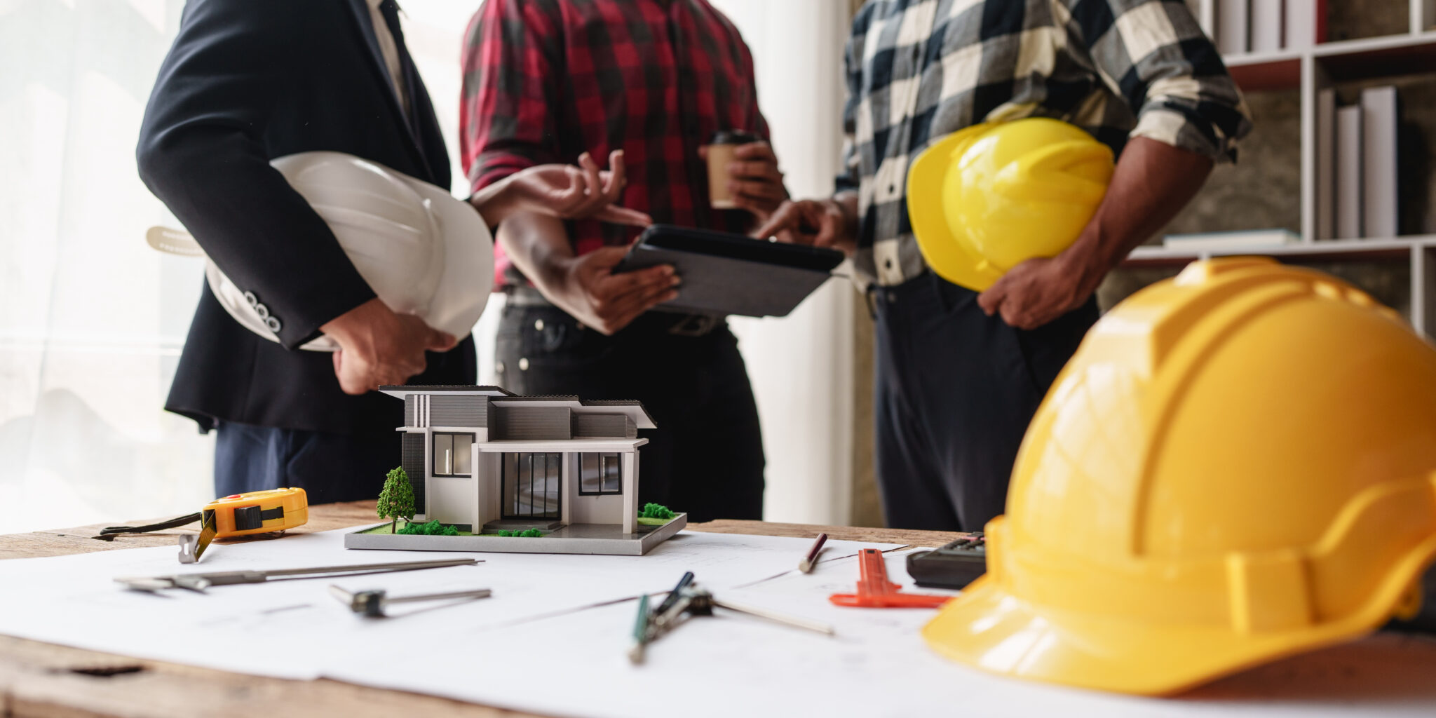 Construction professionals discussing a project around a table, representing planning and lead generation strategies for general contractors