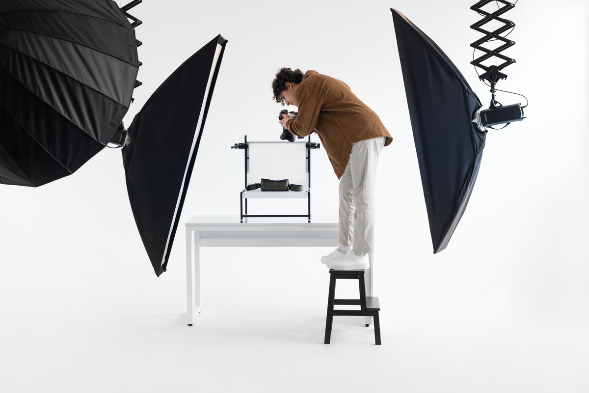 A man stands on a chair, holding a camera, representing creativity in a Houston social media agency setting