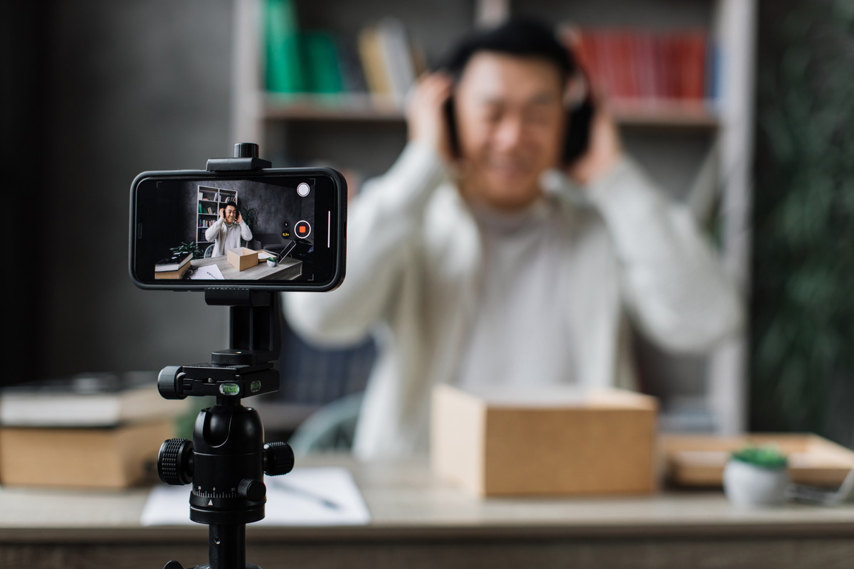 A man records himself during a video call, reflecting 2023's social media marketing trends in personal engagement