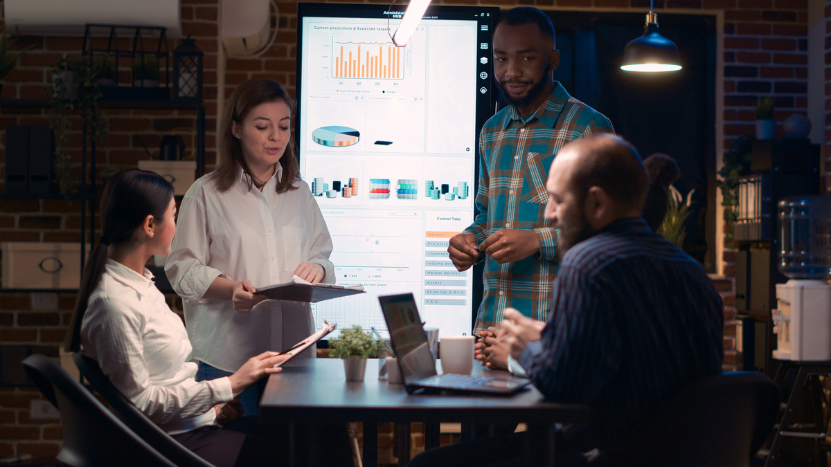 A diverse group of professionals discussing digital marketing strategies in a meeting room with a laptop during a recession
