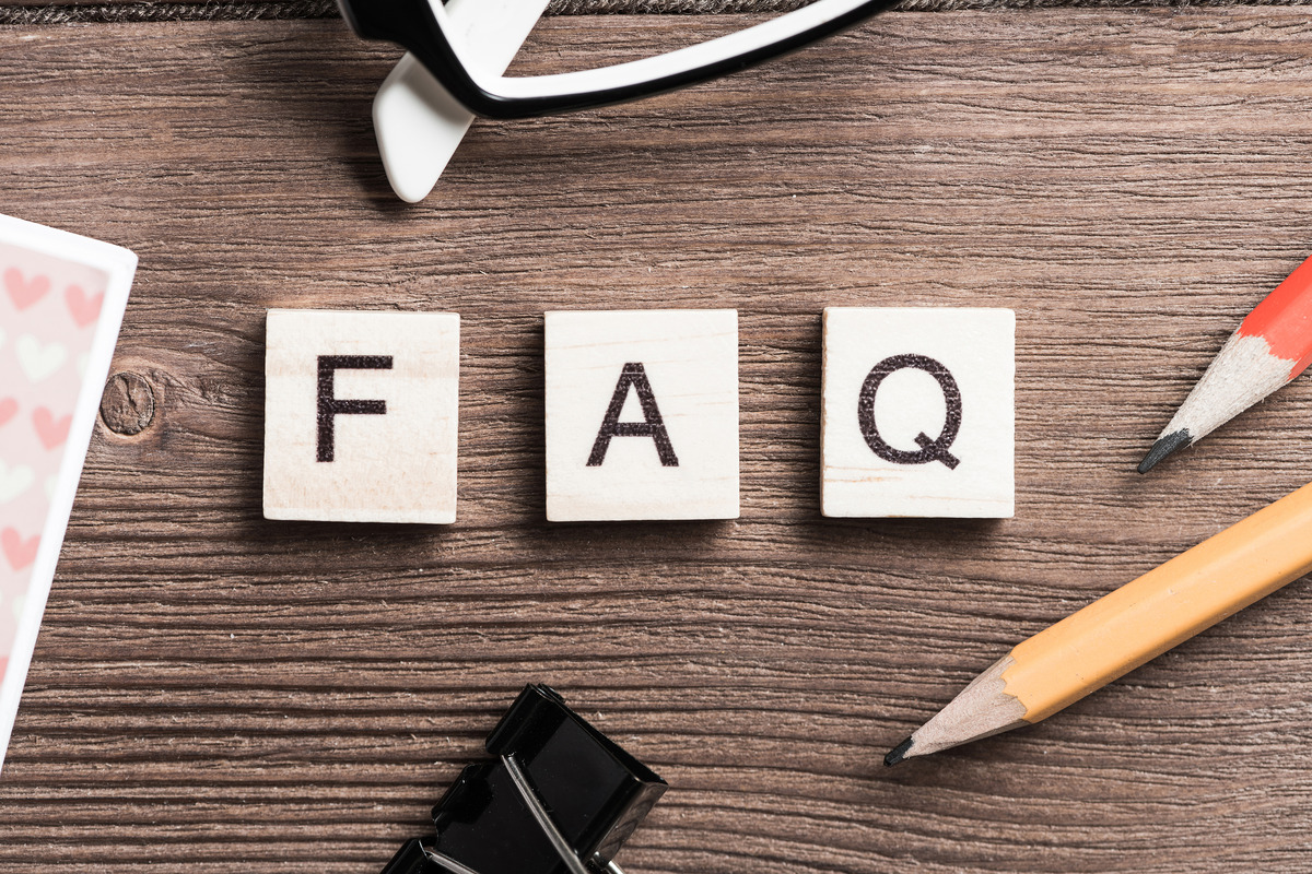 A photo of FAQ letter blocks on the table with office supplies
