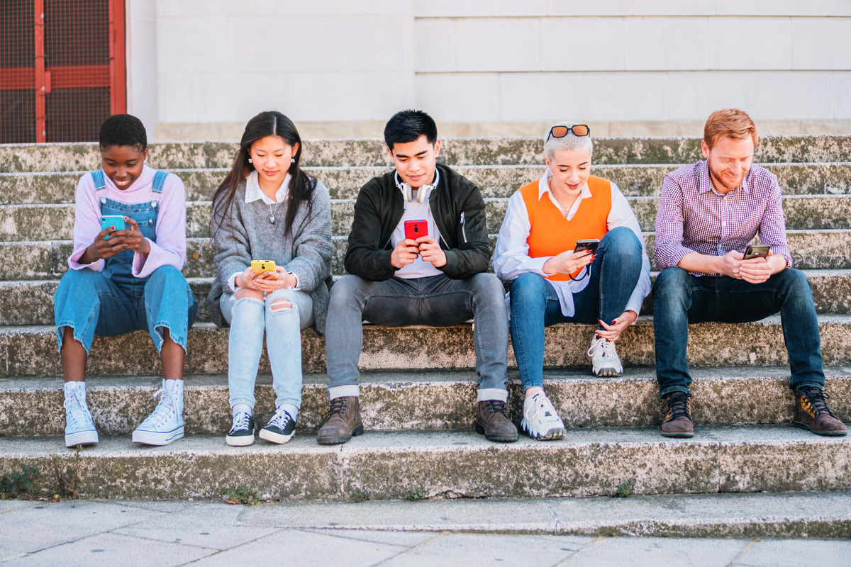 A group of young people that are browsing the web using their phones