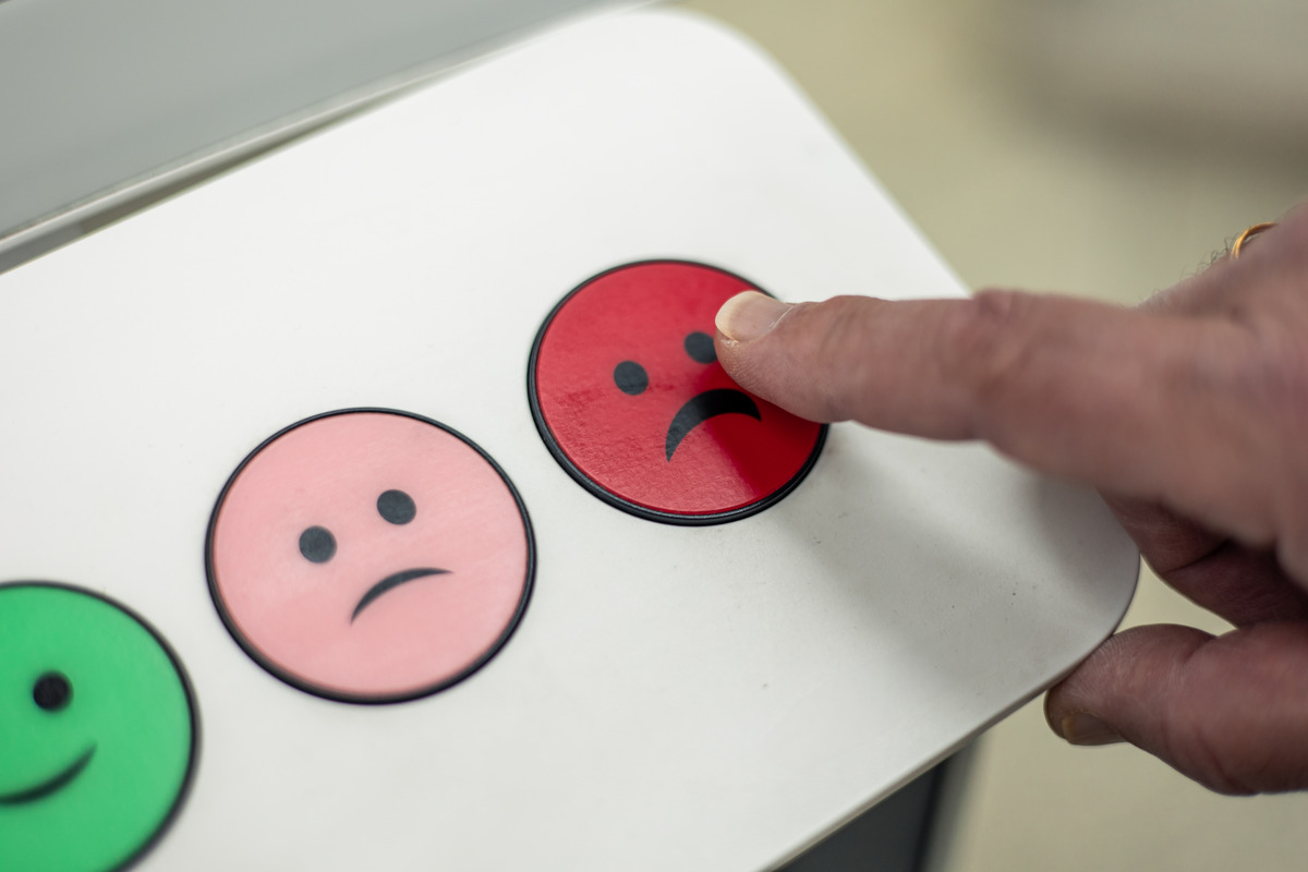 Customer giving Negative Review by pointing on a Sad Icon on a review