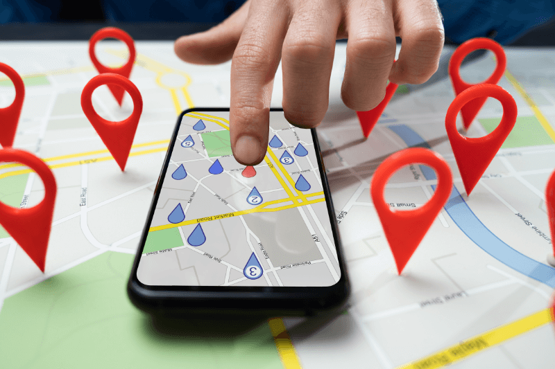 Local SEO marketing concept featuring a smartphone with map markers and red location pins, representing business citations, Google Maps optimization, and geotargeting