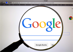 Google search engine optimization and web analysis concept, showing a magnifying glass over the Google logo to represent SEO audits, keyword research, and online visibility
