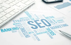 Professional digital marketing concept image showing an SEO word cloud surrounded by data charts and office stationery