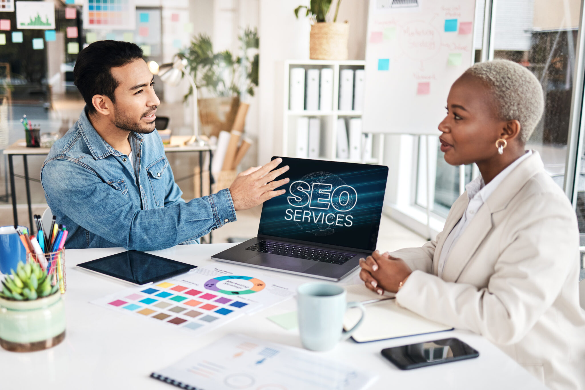 An SEO professional discussing SEO services with his lawyer client in a modern office