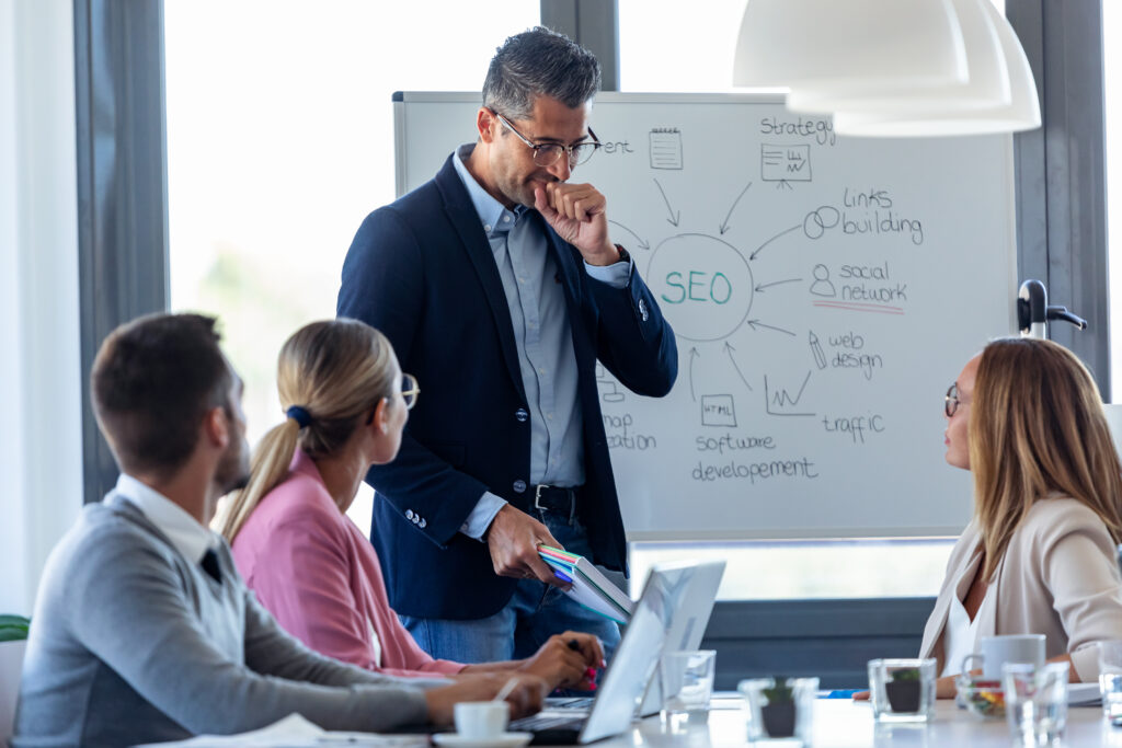 Business meeting discussing SEO strategies for law firms with a whiteboard and a diverse team of SEO professionals