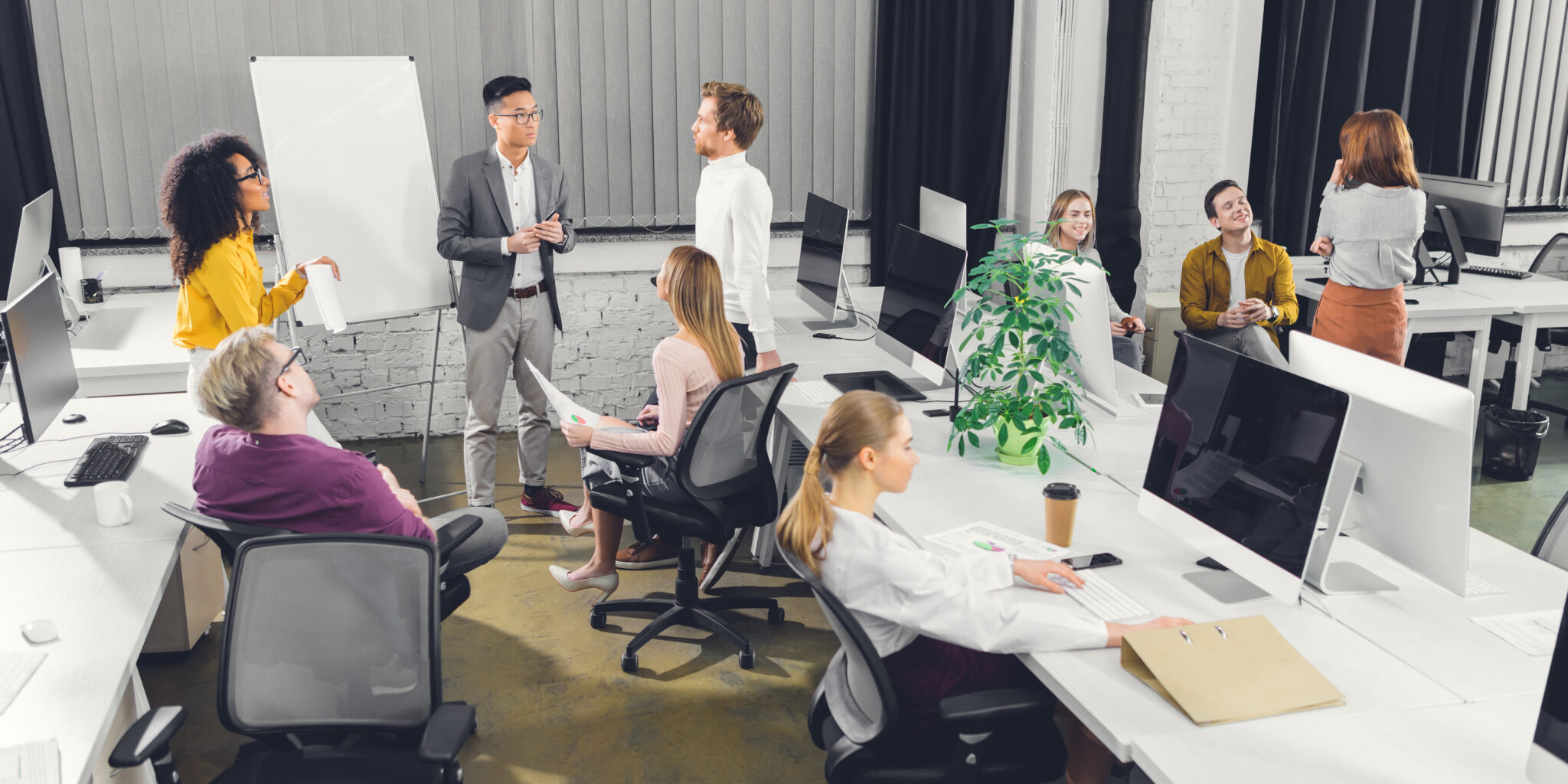 High-angle view of a diverse group of professionals in a modern office, brainstorming about strategies for managing multiple businesses