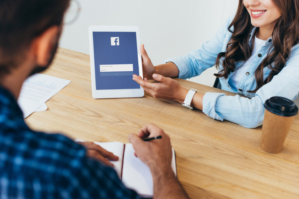 Business professionals discussing social media strategy with a focus on Facebook at a desk