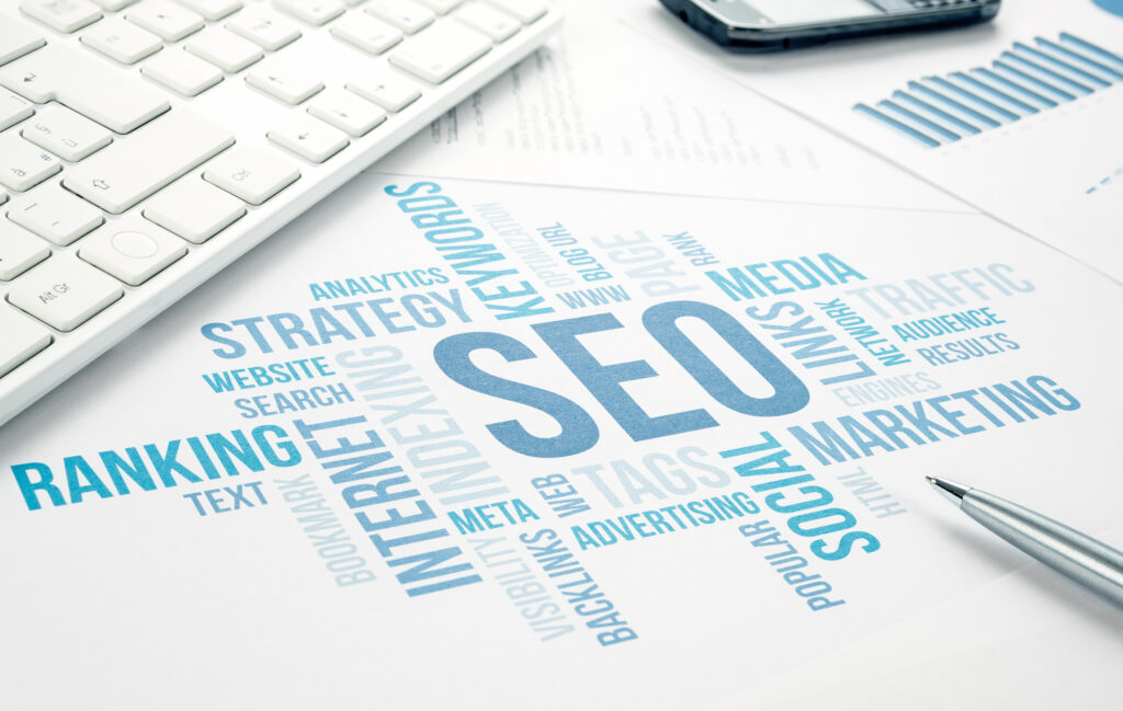 SEO word cloud on a desk with a keyboard and pen, illustrating strategies for startups to boost online visibility and organic growth