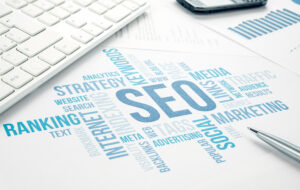SEO word cloud on a desk with a keyboard and pen, illustrating strategies for startups to boost online visibility and organic growth