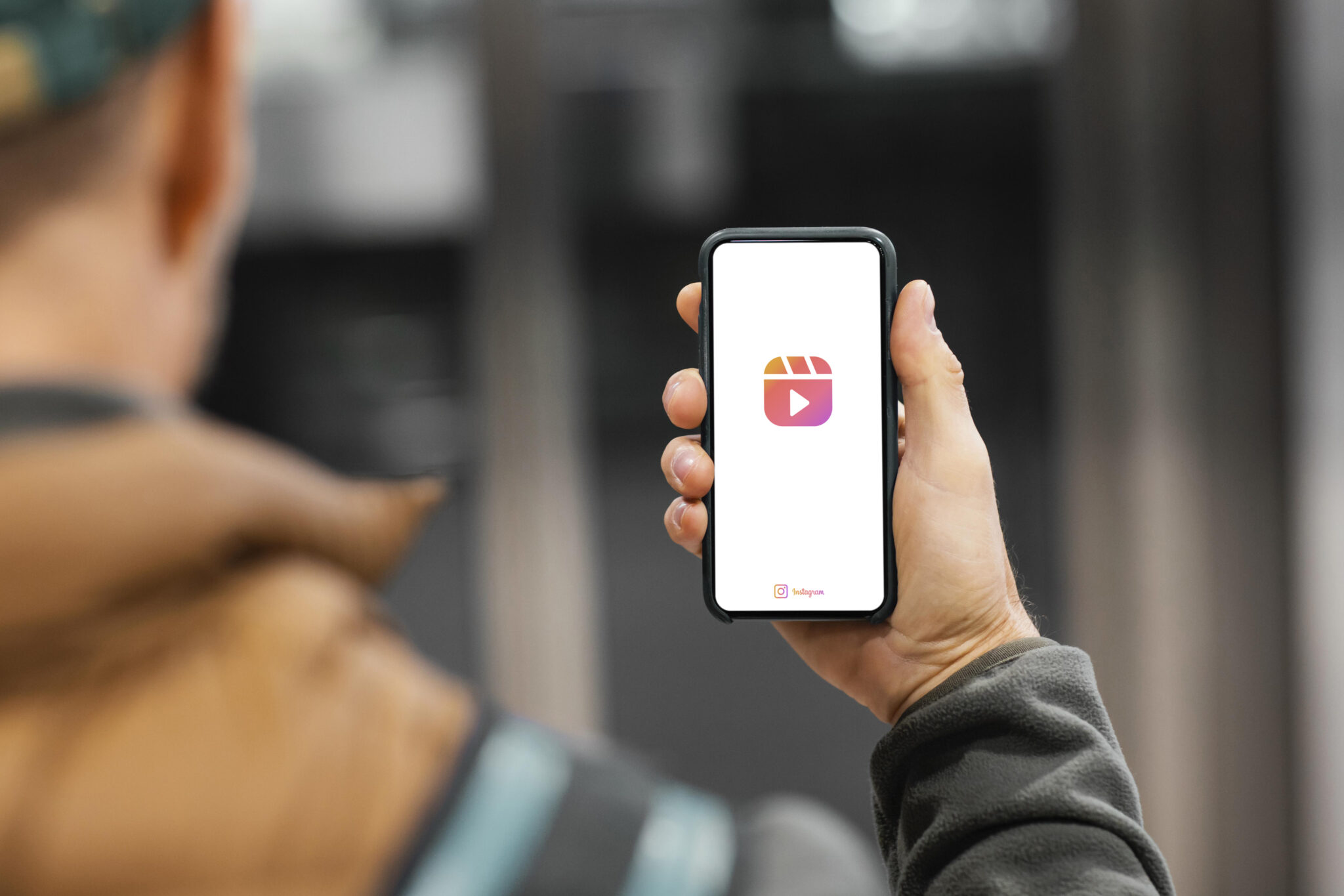 Mobile phone user engaging with the Instagram app, featuring the distinctive Reels video icon, highlighting current trends in vertical video platforms