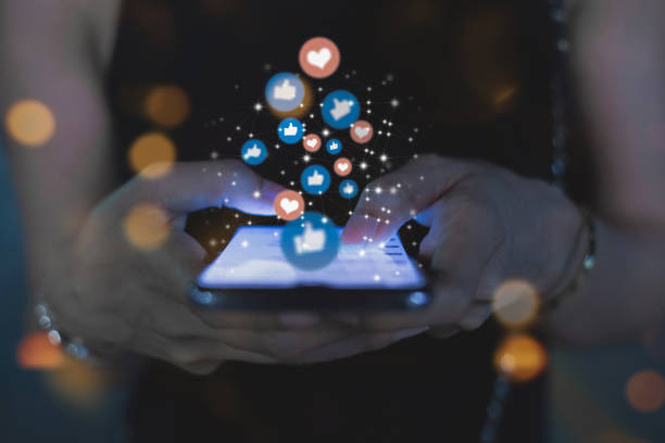A social media user with likes and love reactions floating out of the mobile screen