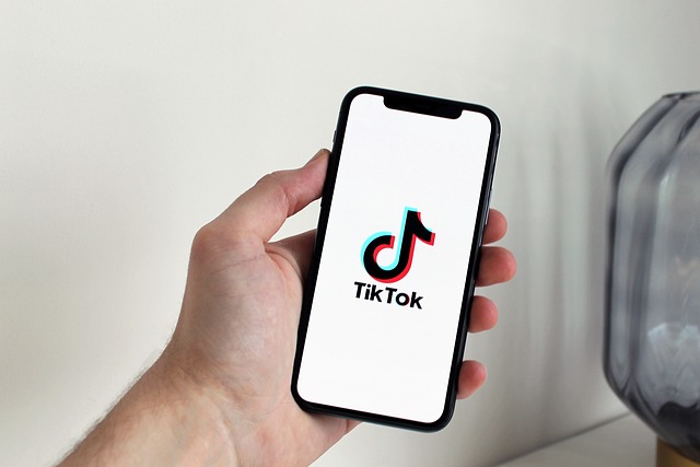 Smartphone displaying the TikTok app logo, representing social media marketing strategies, viral video content creation, and digital brand engagement