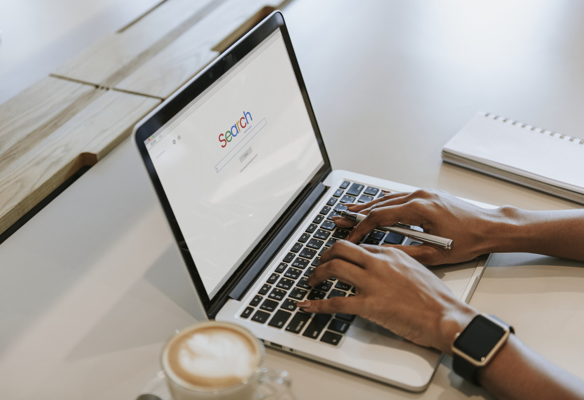 Person searching on Google using a laptop, representing online search, keyword research, search engine optimization (SEO), search intent analysis, and strategies for improving website visibility and organic search rankings.