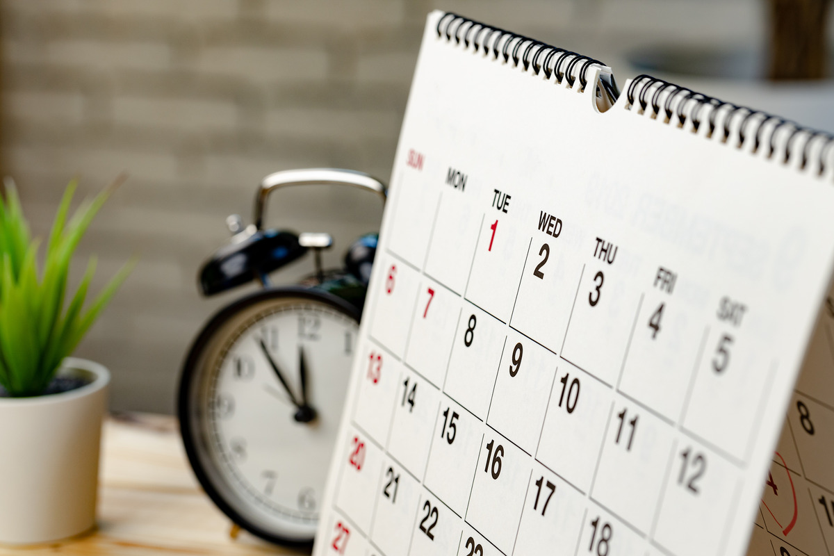 Desk calendar and alarm clock representing SEO timelines, ranking progress, campaign scheduling, long-term search engine optimization, and the time required to improve organic search visibility.
